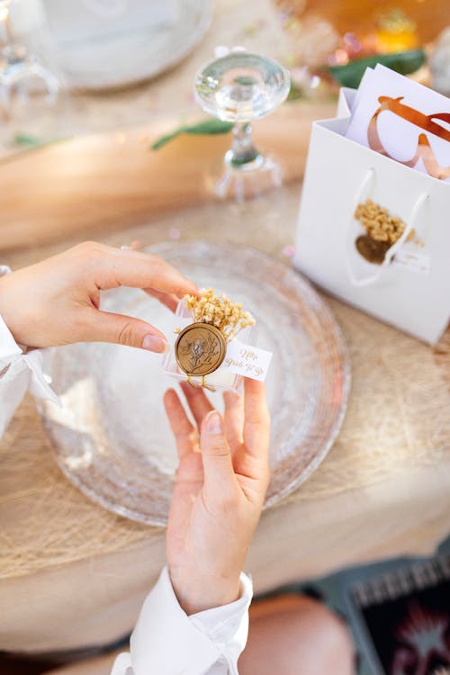 Woman Holding a Small Decoration with Flowers and a Wax Stamp 