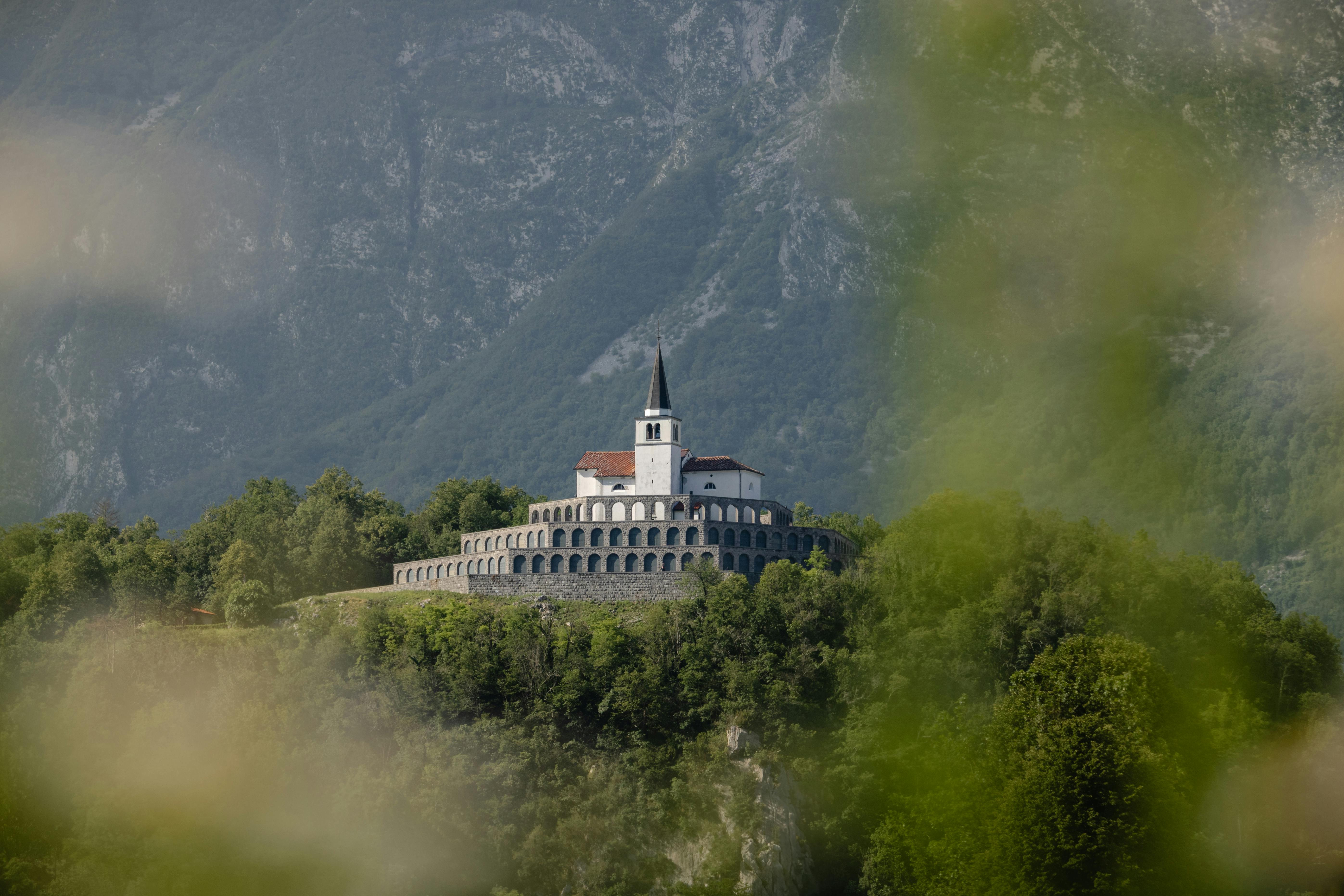 a church on top of a mountain surrounded by trees