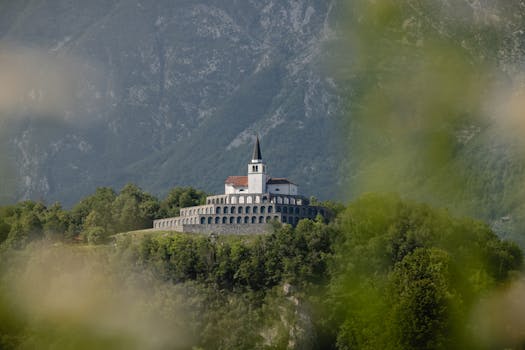 A beautiful church nestled amidst lush greenery and mountains in Kobarid, Slovenia.