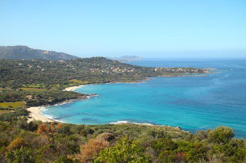 Free A stunning aerial view of L'Île-Rousse coastline in Corsica, showcasing clear blue waters and lush greenery. Stock Photo