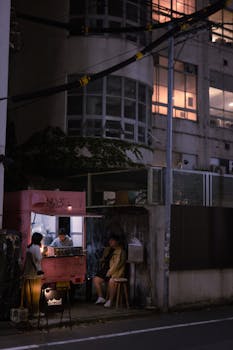 Nighttime shot of a street food stand in Tokyo, capturing urban life and ambiance.