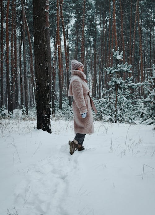 Woman in Coat in Forest in Winter