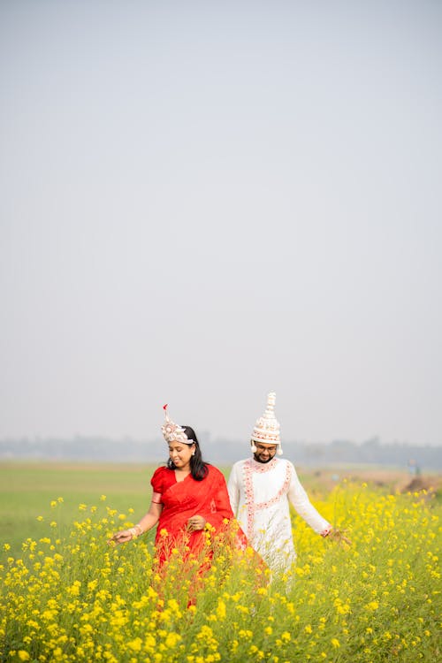 Couple in Traditional Clothing Walking on Meadow