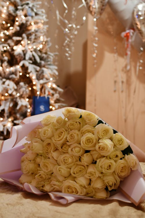 Bouquet of White Roses with Christmas Tree in Background