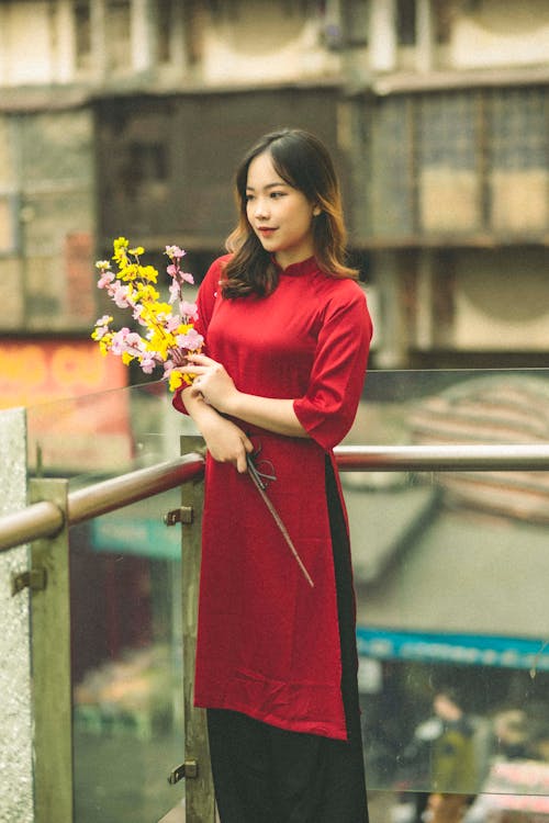 https://images.pexels.com/photos/19759672/pexels-photo-19759672/free-photo-of-a-woman-in-a-red-tunic-with-cherry-blossom.jpeg?auto=compress&cs=tinysrgb&w=1260&h=750&dpr=1
