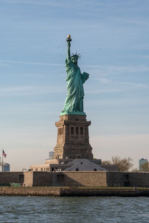 Free The Statue of Liberty standing majestically against a clear sky in New York City. Stock Photo
