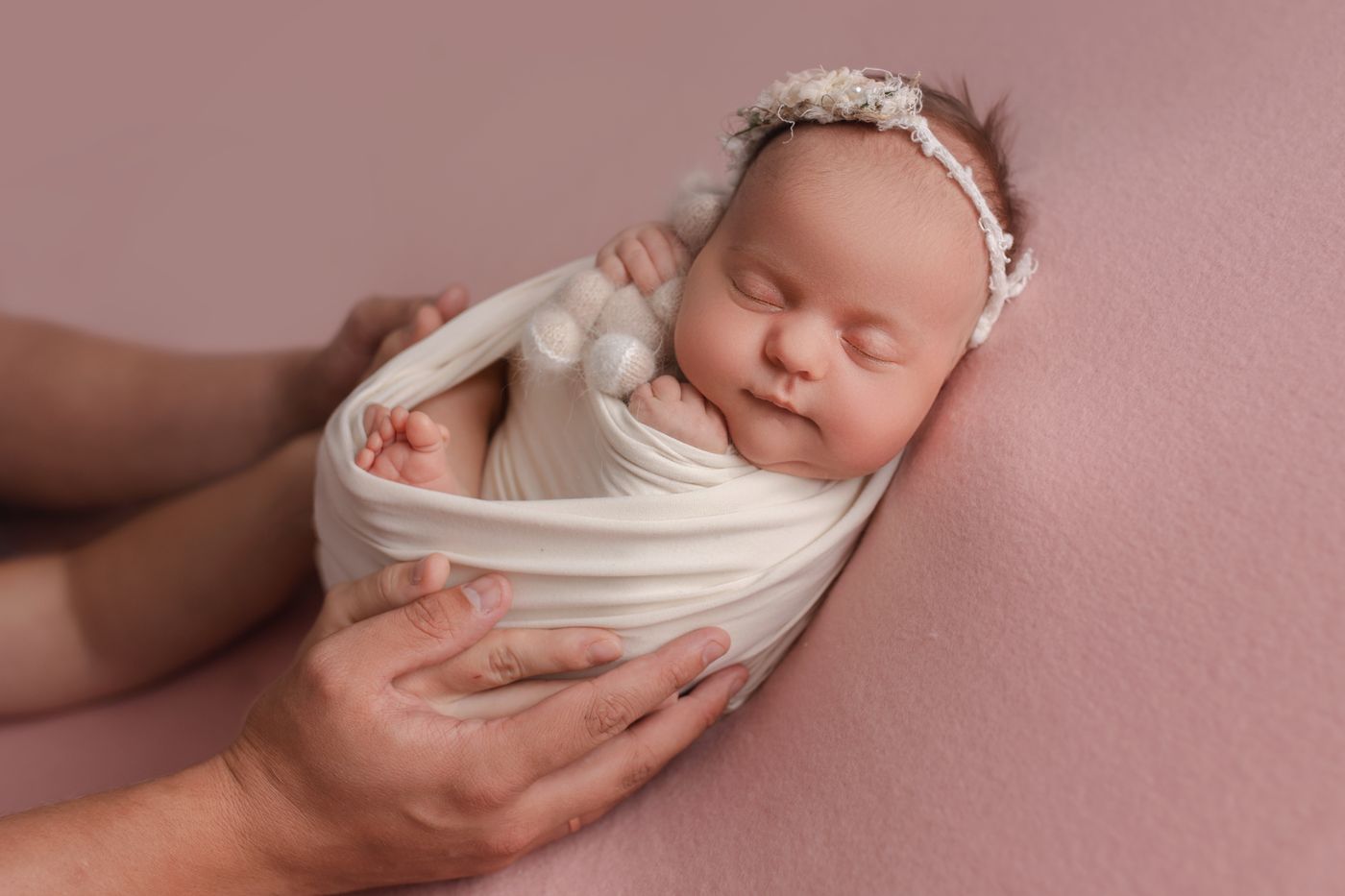 A newborn baby held gently, wrapped in a soft blanket