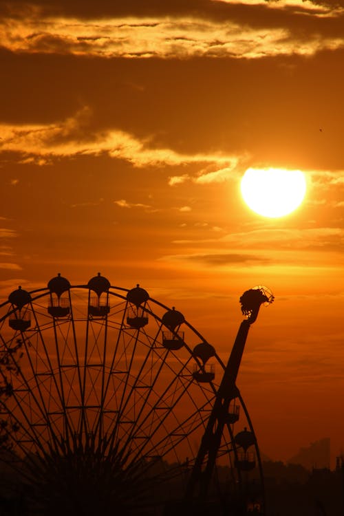 Silhouetted Fairground Rides at Sunset 