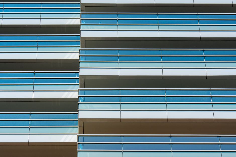 Close-up view of a modern glass facade with architectural lines and reflections.