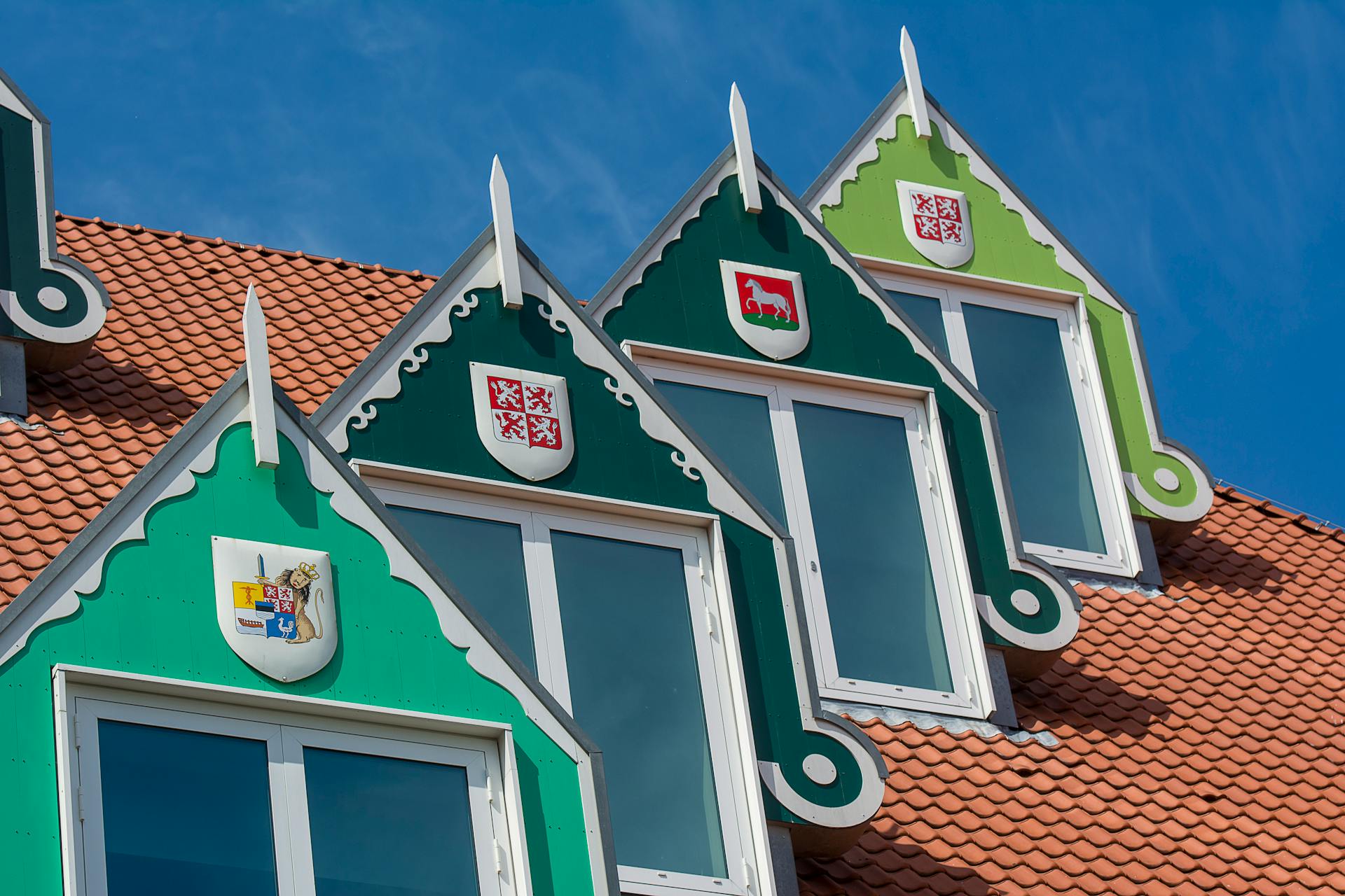 Close-up of vibrant traditional Dutch facades in Zaandam with a clear blue sky.