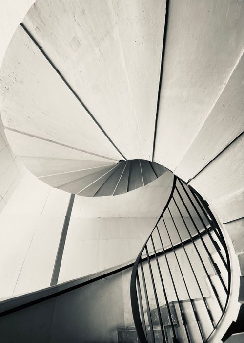 Free Artistic black and white image of a spiral staircase with a modern architectural design. Stock Photo