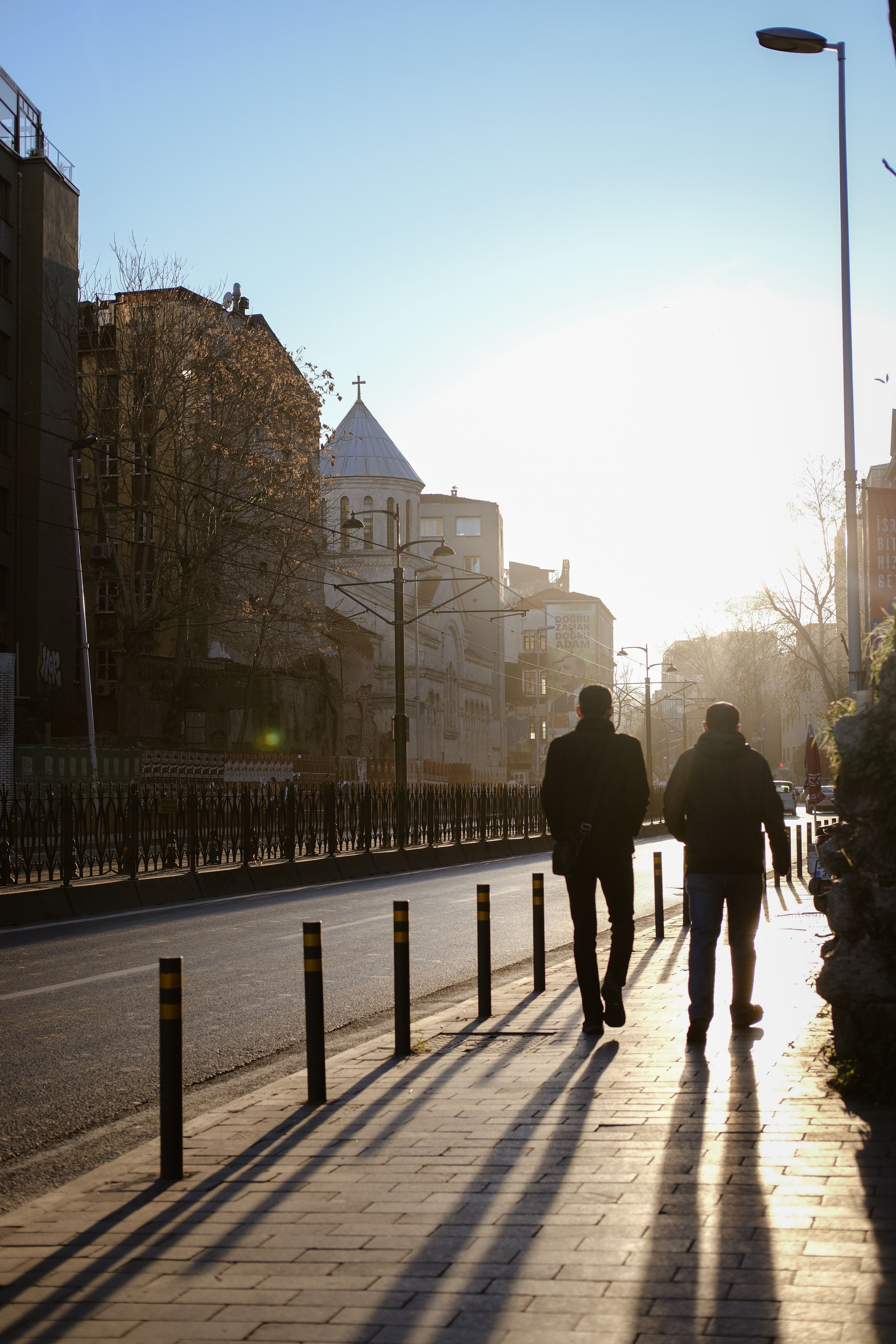 Two people walking down a street at sunset · Free Stock Photo