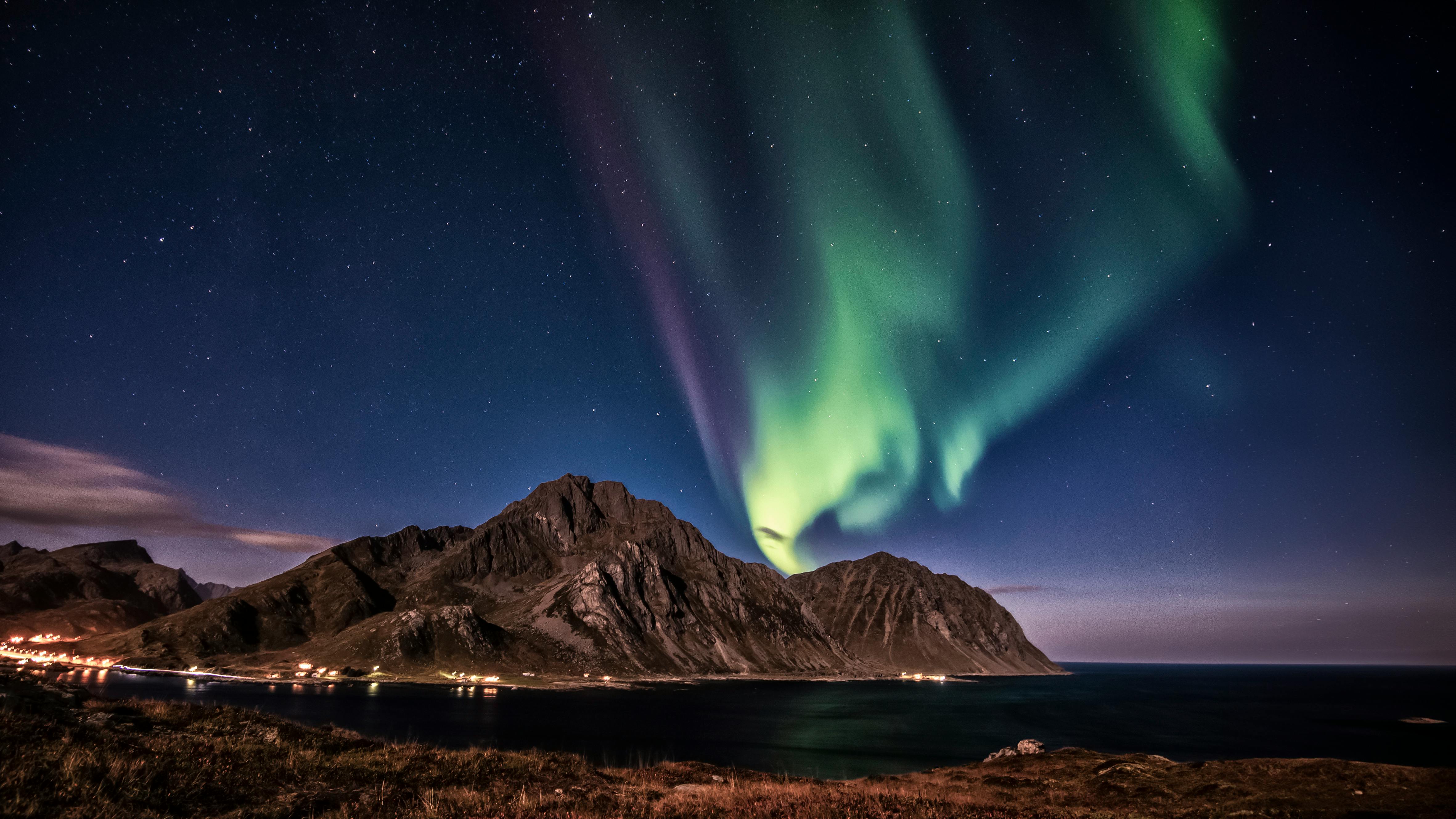 Prescription Goggle Inserts - Stunning Northern Lights over Napp, Norway, with rocky mountains and ocean under a starry sky.