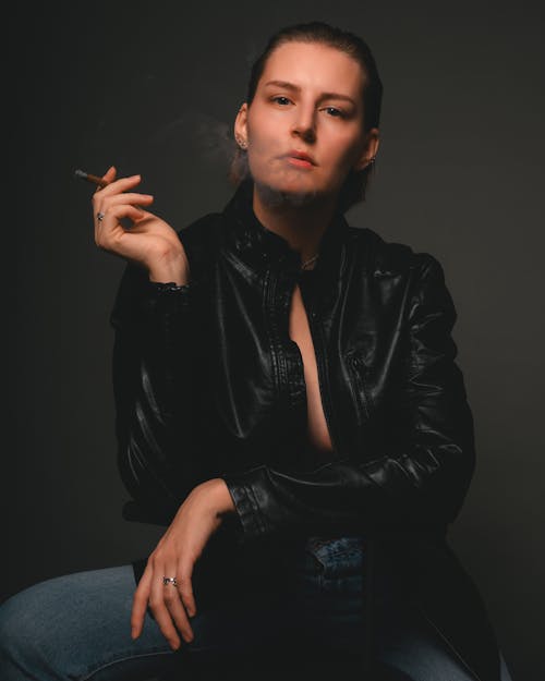 Woman Wearing Leather Jacket and Smoking Cigarette