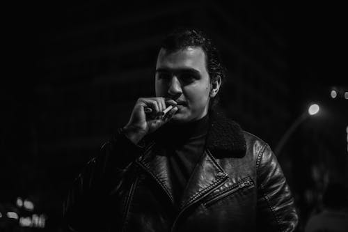 Man in Leather Jacket Smoking Cigarette