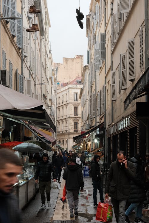 A Crowded Narrow Alley between Buildings with Wooden Window Shutters 