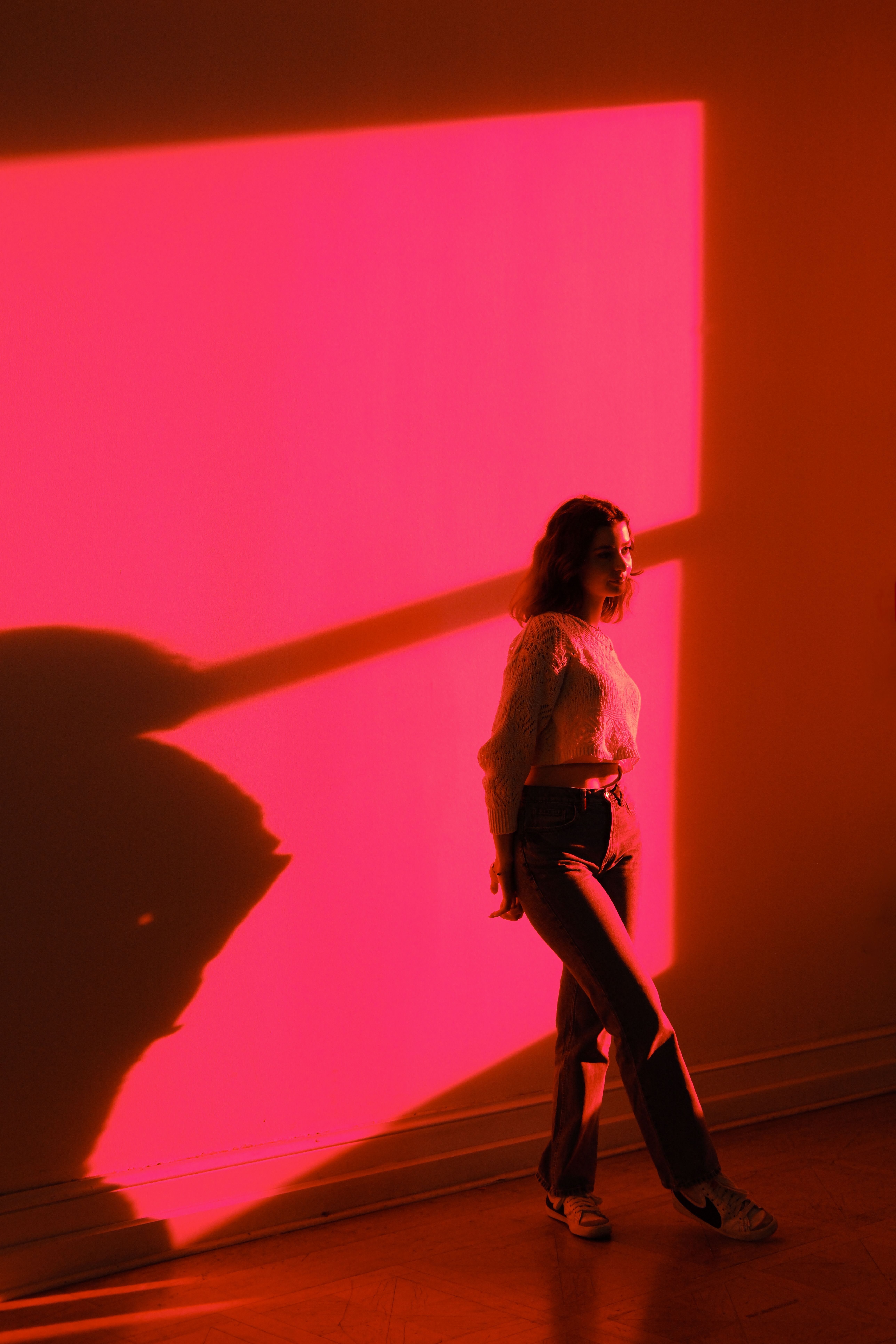 A woman standing in front of a red wall · Free Stock Photo