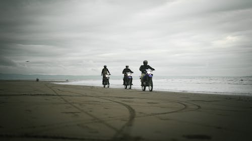 Free Bikers Riding along Sea on Gloomy Day Stock Photo