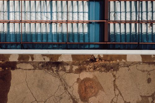 Free An abstract view of a cracked pavement with barred windows in Tucumcari, NM. Stock Photo
