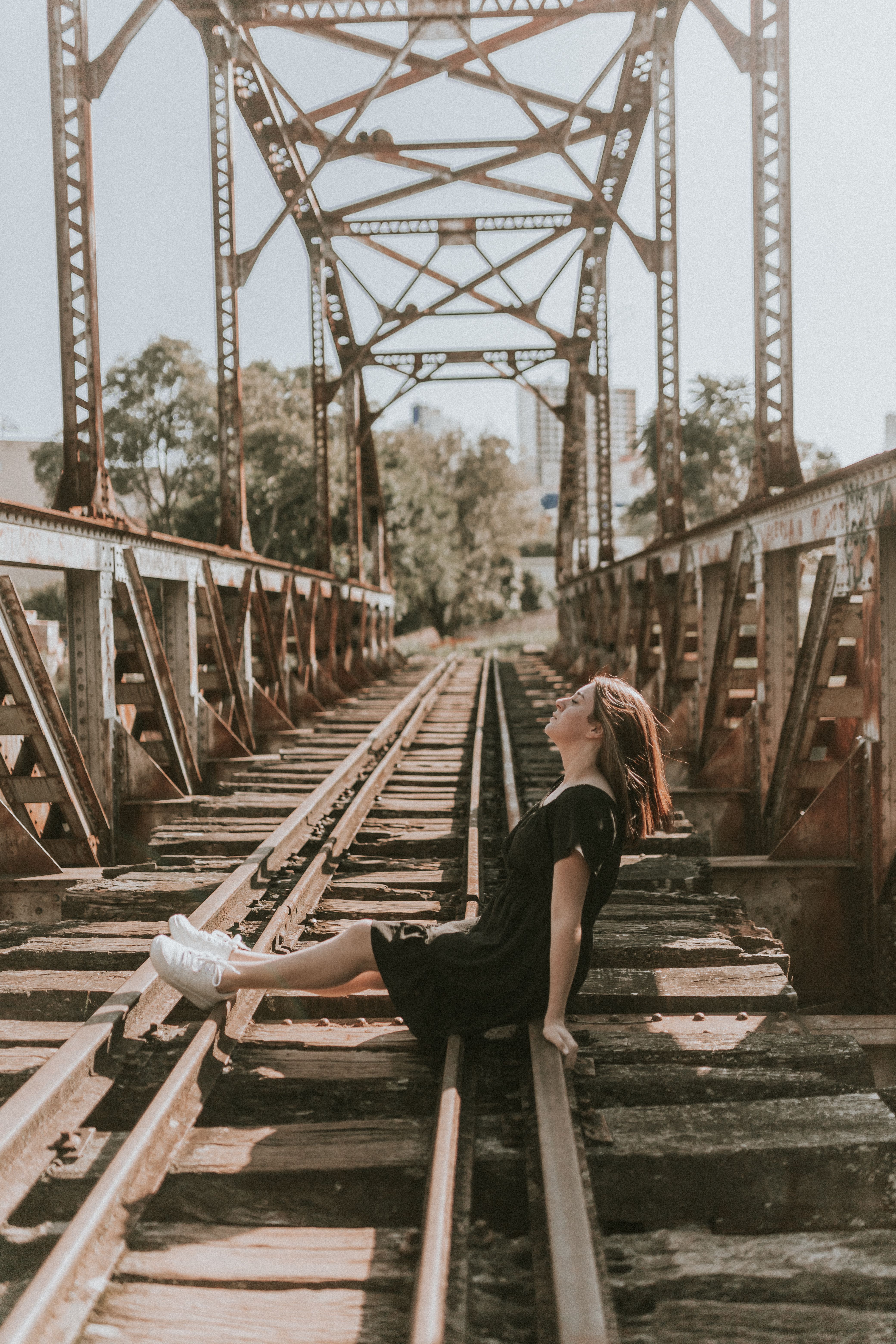 Woman in Black Dress Posing on Railway Tracks · Free Stock Photo