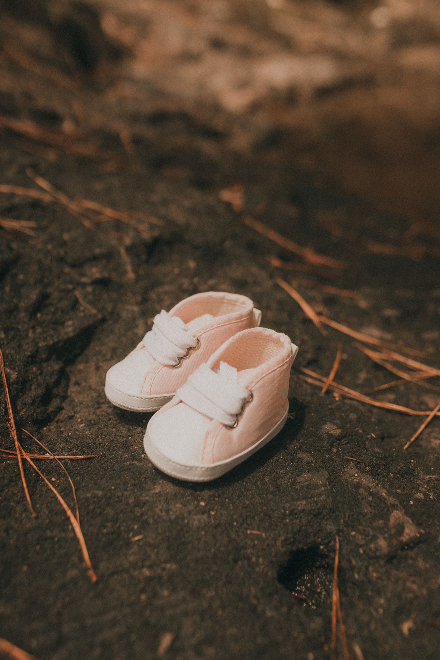 Pink baby first walker shoes on a natural stone surface