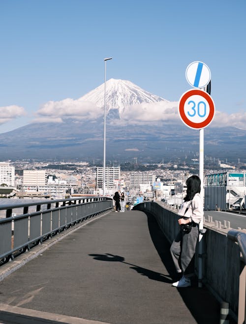 Woman Standing on Footbridge with Fuji Mountain behind