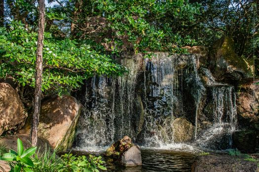 Tranquil waterfall in a lush Japanese garden setting, perfect for relaxation.