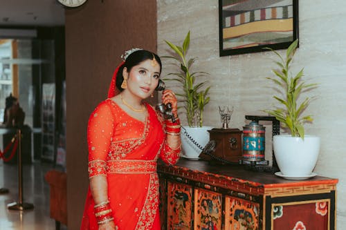 Woman in Traditional Clothing Standing with Telephone Handset