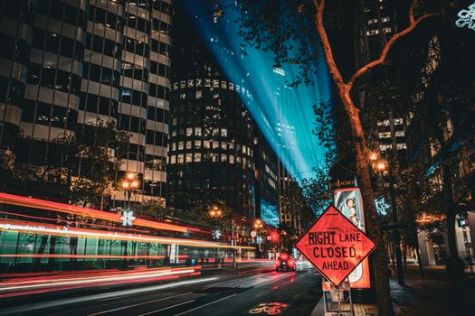 Illuminated streets of San Francisco with light trails and towering skyscrapers at night.