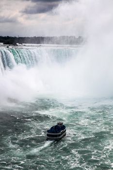 A tour boat approaches the majestic Niagara Falls, showcasing its stunning natural beauty and power.