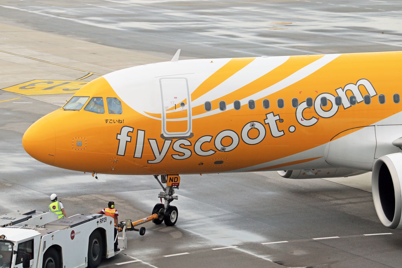 Avión y tractor de apoyo en tierra en plataforma aeroportuaria