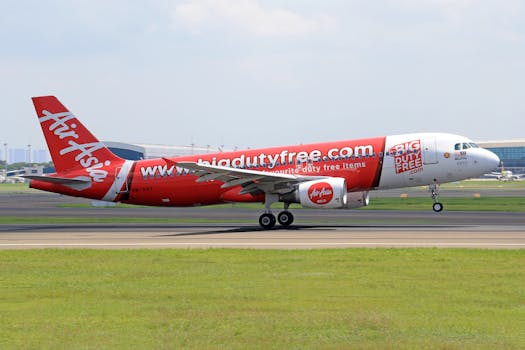 AirAsia Airbus A320 landing at an airport runway on a bright sunny day.