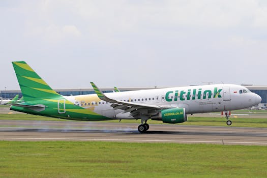 Citilink Airbus A320 making a landing on a runway with visible tire smoke.