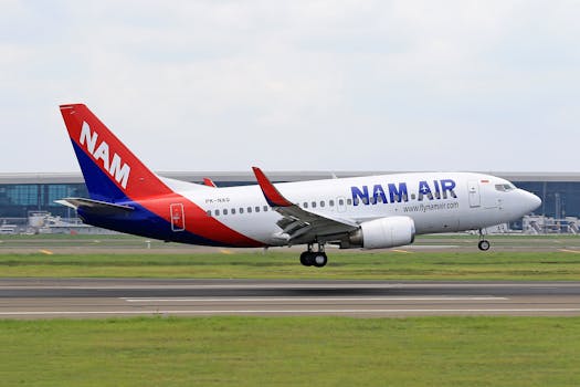 NAM Air Boeing 737 airplane taking off from a runway, captured during daytime.