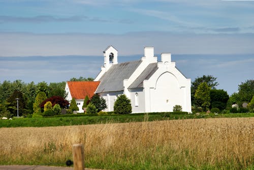 Beautiful Rural Church Surrounded by Lush Green Fields and Open Sky
