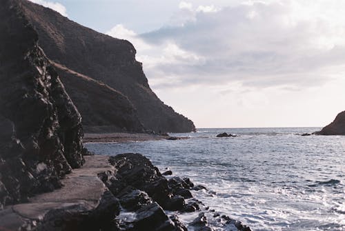 View of a Cliff and Rock Formations on a Shore 