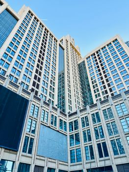 Tall skyscrapers in Tianjin's financial district under a clear blue sky, showcasing urban architecture.