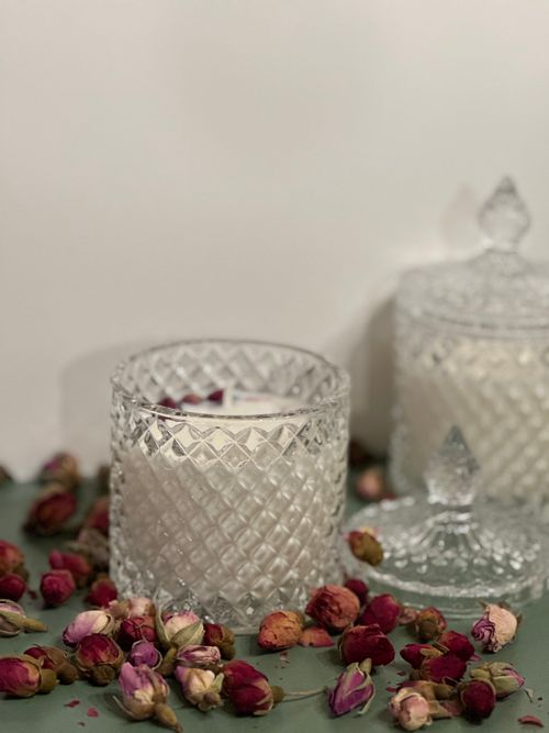 Free Delicate glass candle holders surrounded by scattered dried roses create a serene still life composition. Stock Photo