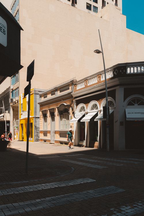 Free A sunlit urban street featuring historic architecture and modern elements. Stock Photo