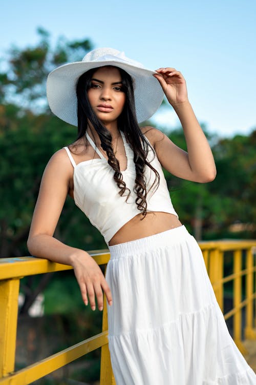 Woman in a White Hat and Tank Top Leaning on the Railing 