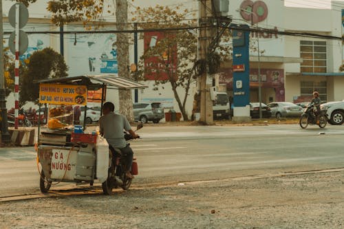 Man Riding on Motorbike with Street Food Cart