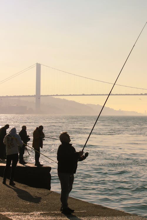 Man Fishing in Sea Bay at Sunset