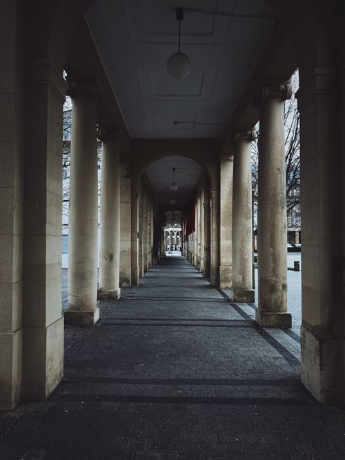 Free A symmetrical shot of urban passage with columns, creating a sense of depth and elegance. Stock Photo