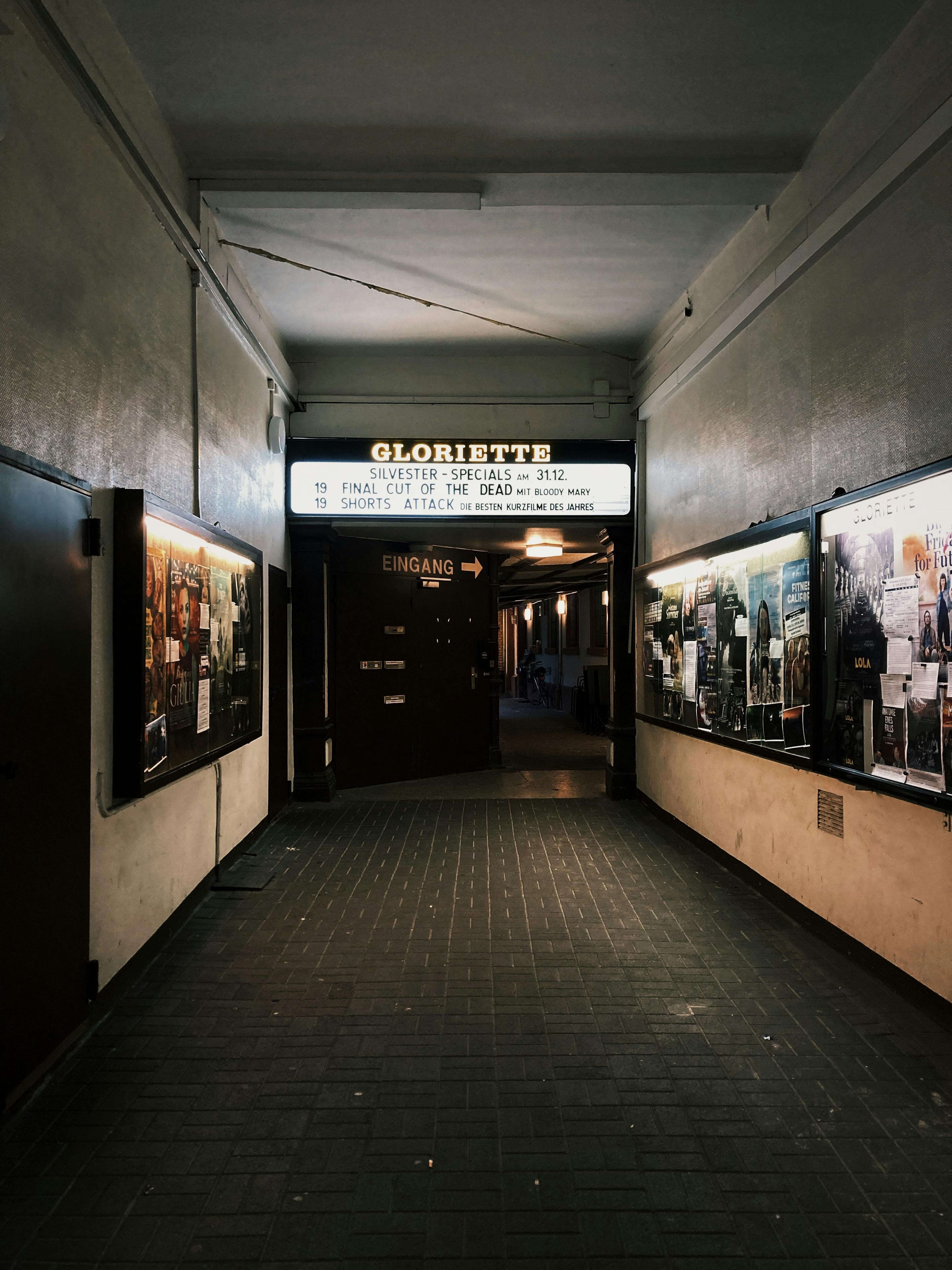 Dimly lit urban hallway with a Gloriette sign and vintage displays on the walls.