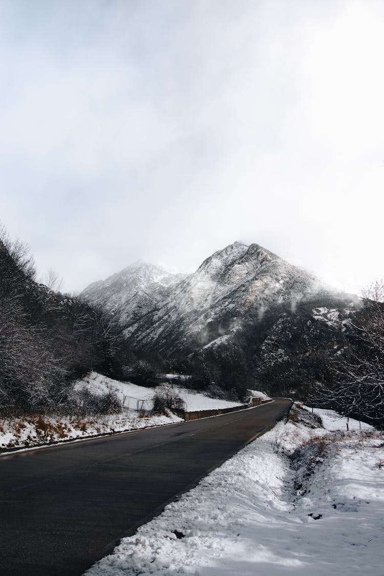 Road Leading To Snow Covered Mountains