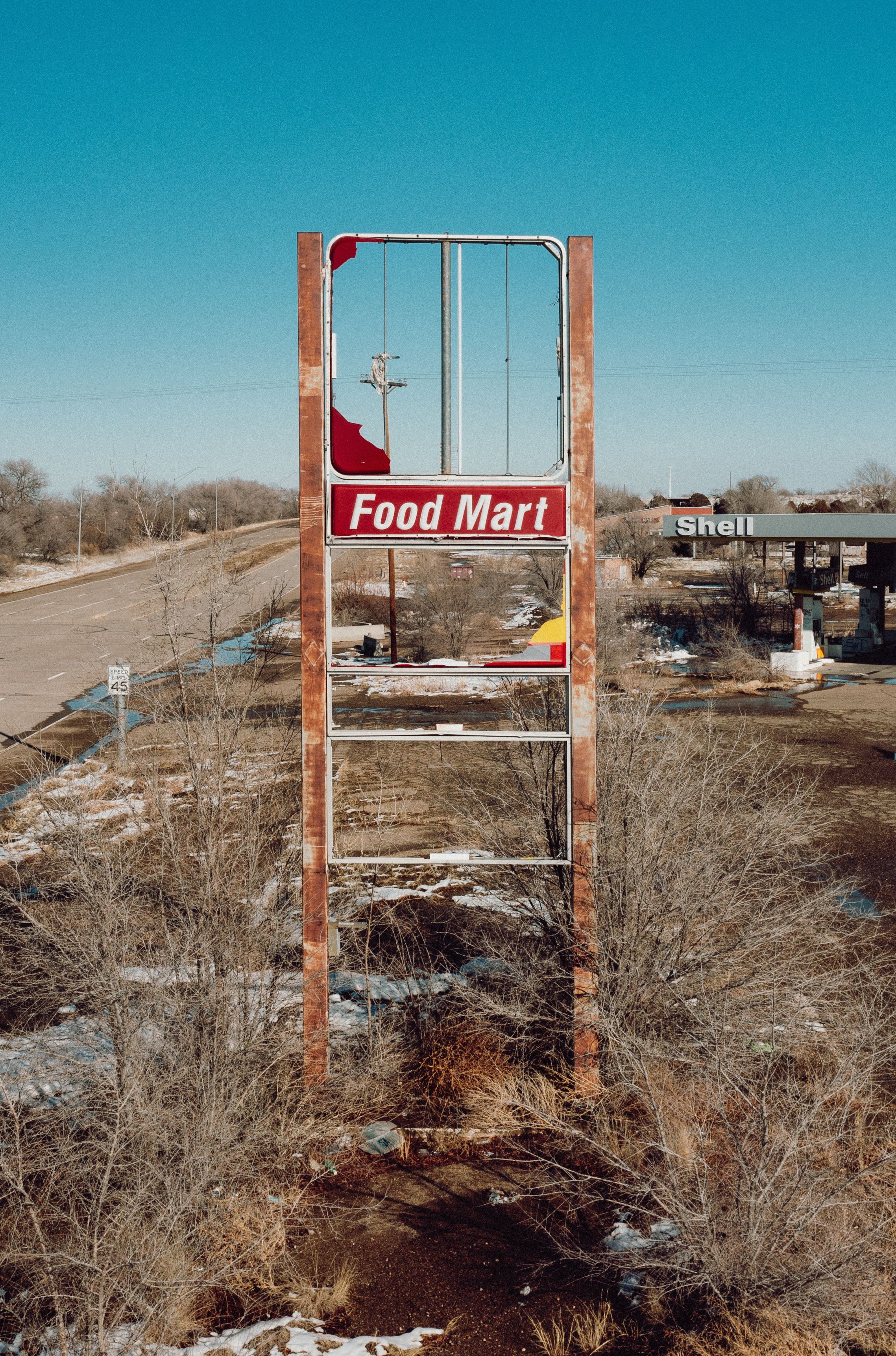Rusty food mart sign in Tucumcari, NM, capturing rural decay.