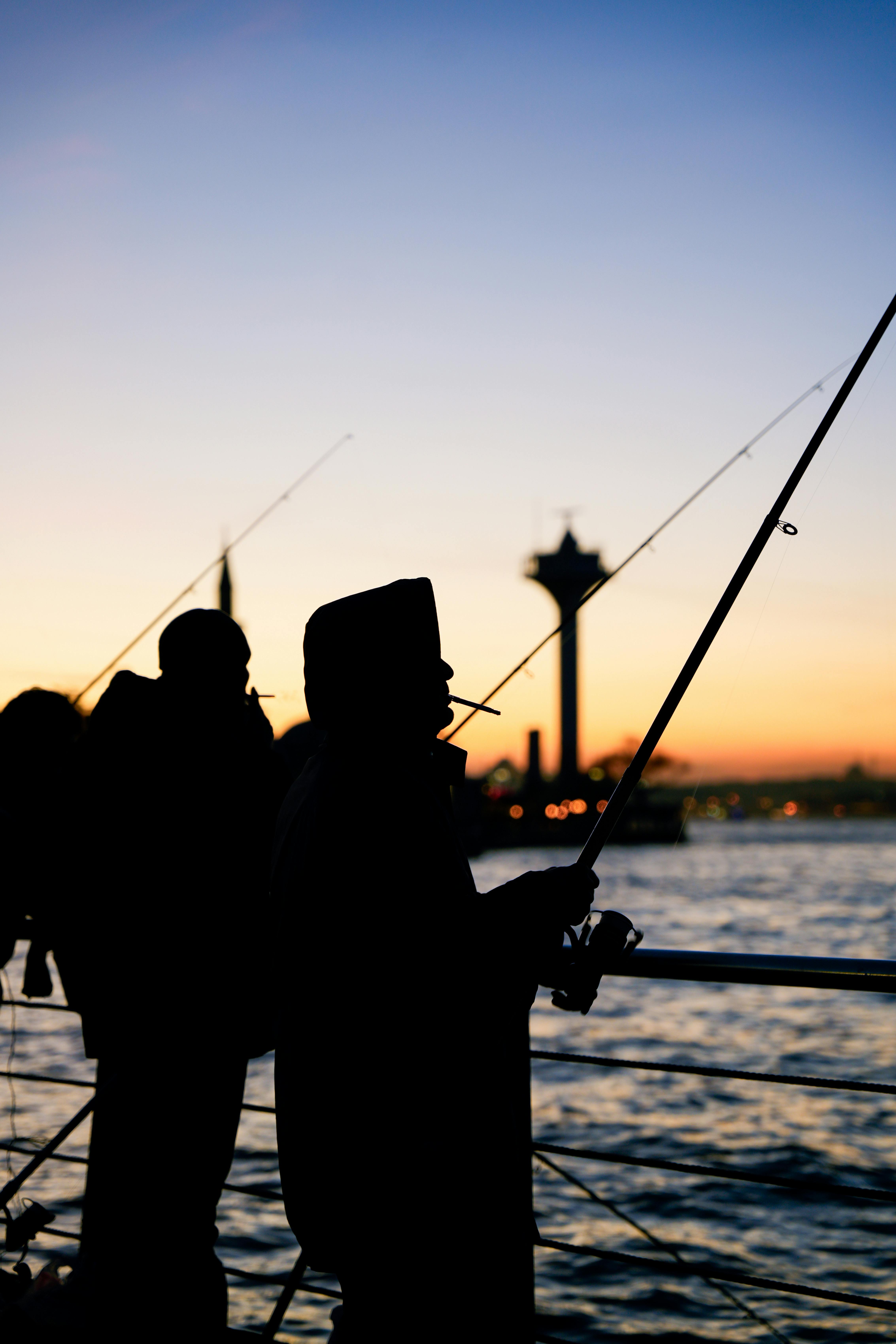 Men Fishing in the Sea from the Pier at Sunset · Free Stock Photo