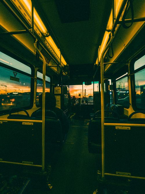 Free A scenic view from inside a city bus during sunset, with an urban skyline visible through the windows. Stock Photo