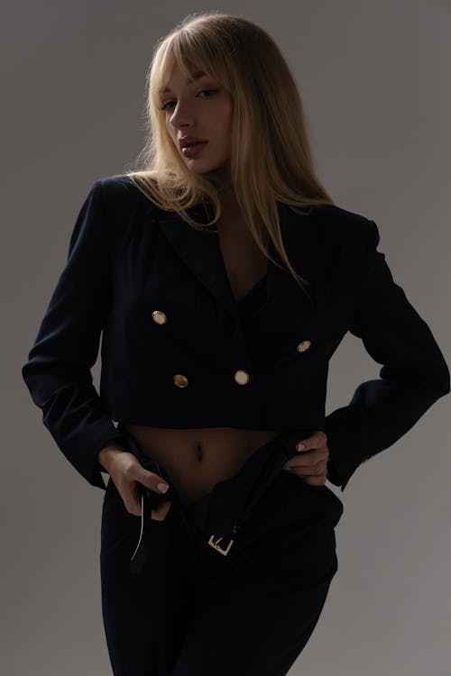Young Model in a Black Bolero with Golden Buttons and Pants with an Unfastened Belt