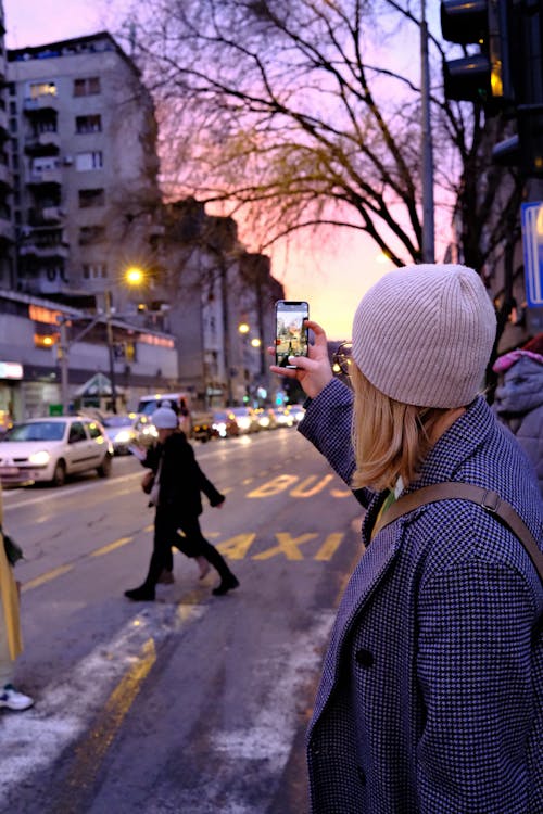 Woman Taking a Picture of the City at Sunset 